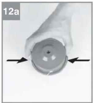 Close-up of a hand holding a circular mechanical component with two arrows pointing to it (no text or symbols visible)