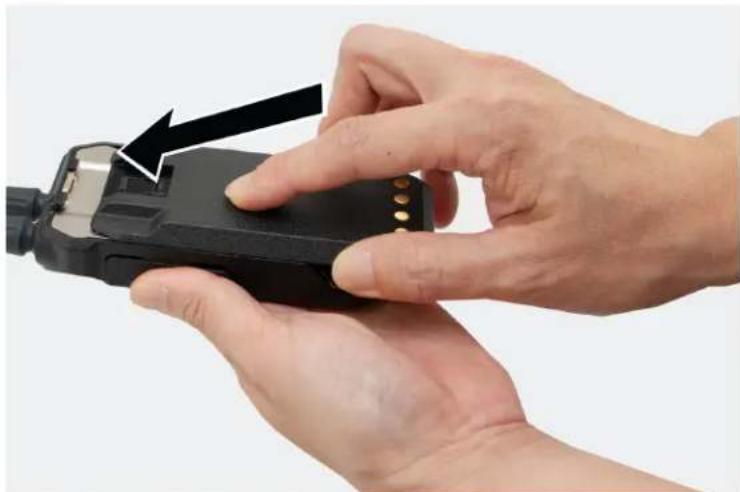 Close-up of hands holding a black handheld device with a black arrow pointing to the handle (no text or symbols visible)