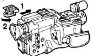 Technical diagram of a digital camera with labeled parts and directional arrows indicating motion or assembly.