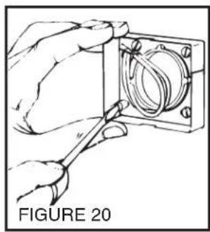 Hand holding a tool inside a mechanical component, labeled 'FIGURE 20' (no other text or symbols)