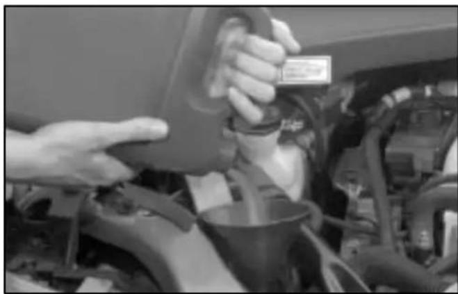Close-up of hands inspecting a car engine compartment with visible engine and dashboard (no text or symbols)