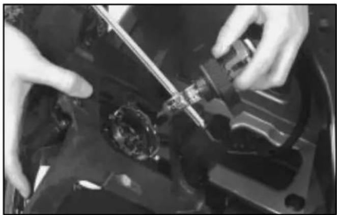 Close-up of hands installing or adjusting a mechanical component on a dark vehicle (no visible text or symbols)