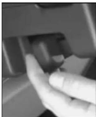 Close-up of a hand pressing a button on a mechanical component (no visible text or symbols)