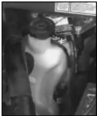 Interior view of a vehicle or workshop with a person wearing a helmet and glasses (no visible text or symbols)
