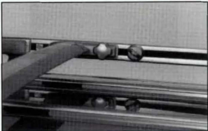 Close-up of a mechanical device with a lever and roller, no visible text or symbols