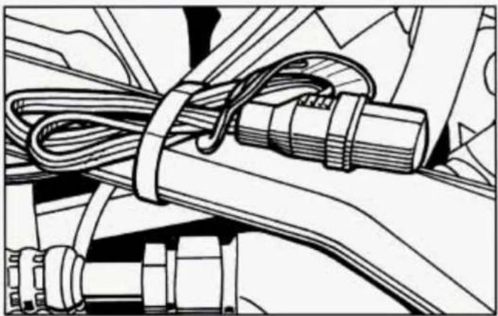 Technical line drawing of a mechanical assembly with coiled cable and clamped components (no text or symbols)
