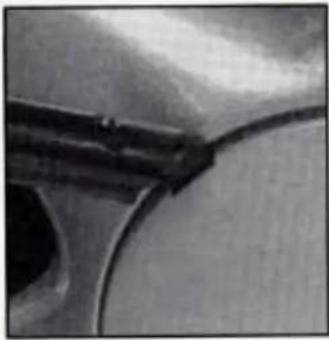 Close-up of a curved mechanical component or tool interacting with a surface (no visible text or symbols)