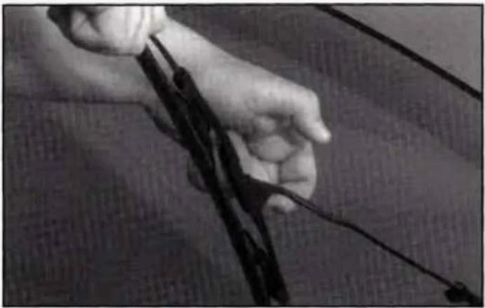 Close-up of a hand holding a black object with wires, no visible text or symbols