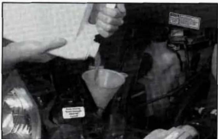 Person pouring liquid into a funnel in a lab setting (no visible text or symbols)