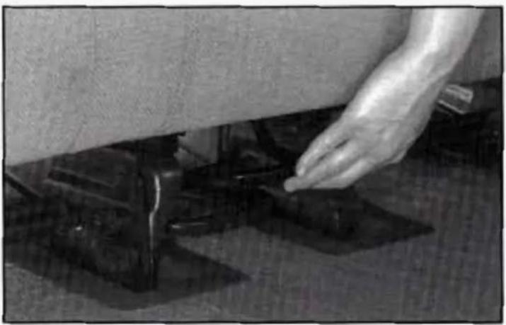 Close-up of a hand pressing down on a dark surface with glossy texture (no text or symbols visible)