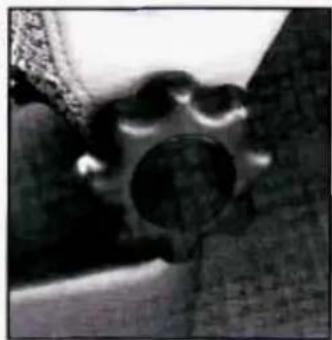 Close-up of a mechanical component with a circular hole and textured surface (no visible text or symbols)