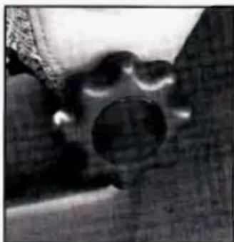 Close-up of a mechanical component with a circular hole and textured surface (no visible text or symbols)