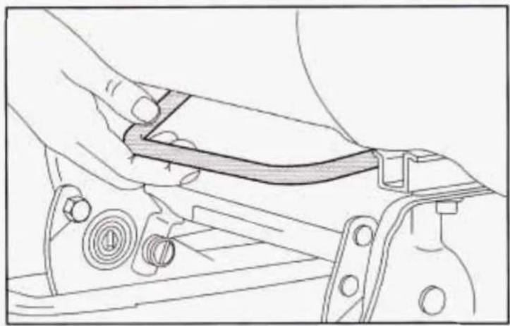 Technical line drawing of a mechanical assembly with a hand adjusting a component (no text or symbols)