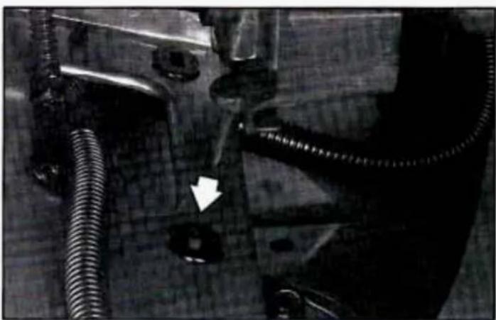 Close-up of mechanical components including hoses and a bolt, with no visible text or symbols