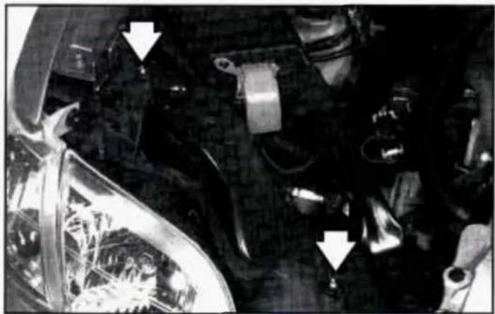 Close-up of an automotive engine bay with visible structural components and directional arrows (no text or symbols)