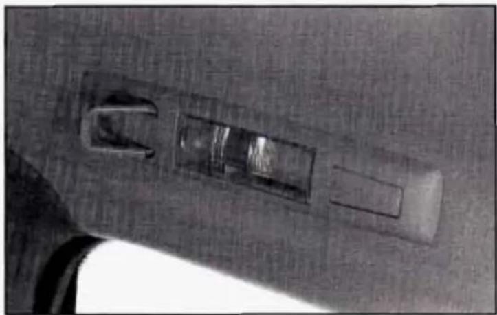 Close-up of a car's side panel showing a handle and vent, with no visible text or symbols