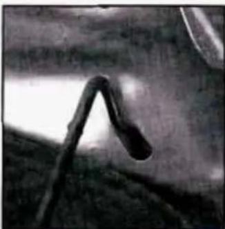Close-up of a curved, dark object with a bright light beam, possibly a tool or component (no visible text or symbols)