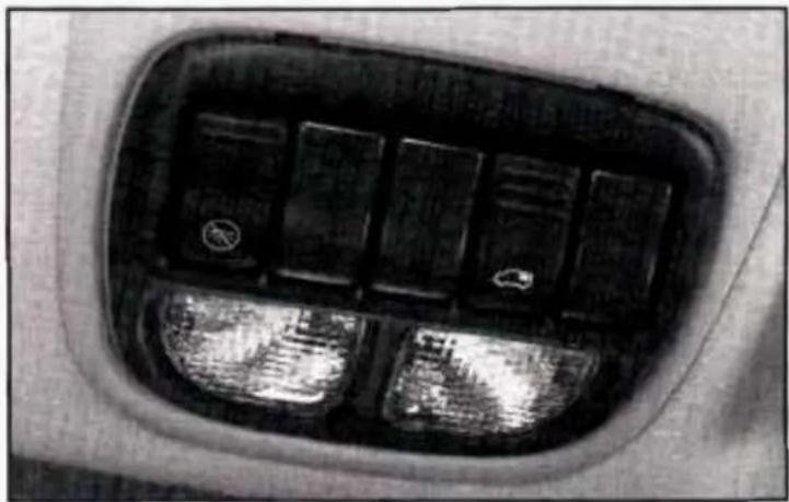 Close-up of a car air vent with illuminated buttons and a small circular icon (no text or symbols visible)