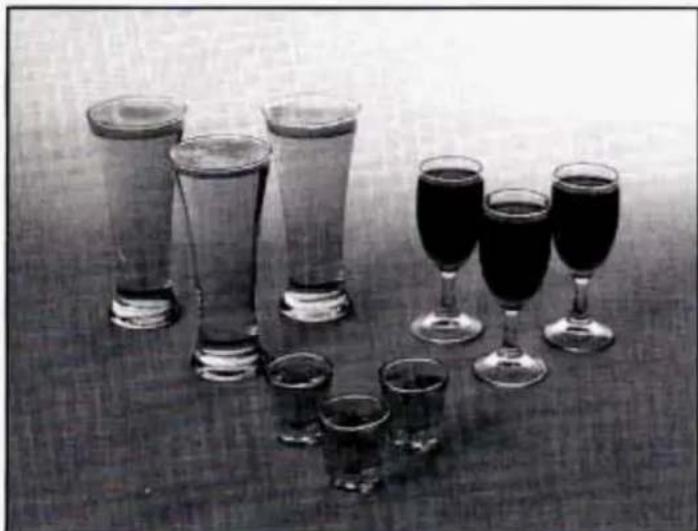 Black-and-white photo of multiple glasses and wine glasses arranged on a table, no text or symbols visible