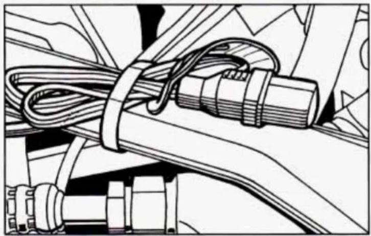 Technical line drawing of a mechanical assembly with coiled cable and clamped components (no text or symbols)