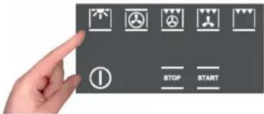 Hand holding a control panel with icons for stop and start functions, including warning symbols and a 'STOP' button.