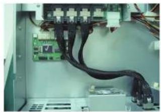 Interior view of an electronic device showing a circuit board connected to a black cable (no visible text or symbols)