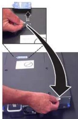 Instructional diagram showing a hand using a tool to adjust or remove a device, with arrows indicating the process and a magnified view of the device's components.
