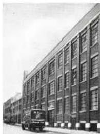 Exterior view of a multi-story building with a parked truck in front (no visible text or signage)