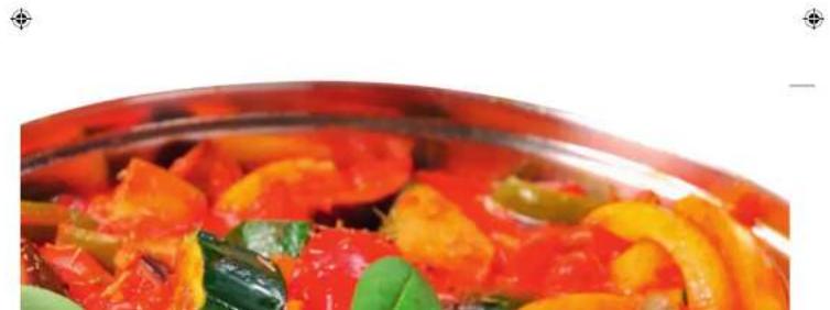 Close-up of a colorful vegetable dish in a glass bowl, featuring sliced tomatoes and green peppers (no text or symbols visible)