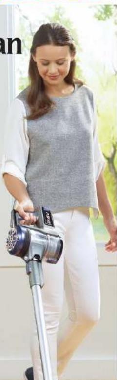 Woman using a handheld vacuum cleaner in a studio setting (no visible text or symbols)