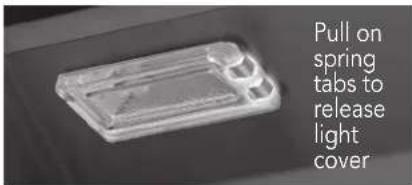 Pull on spring tabs to release light cover