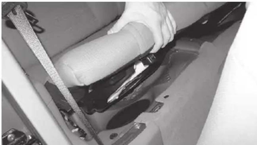Close-up of hands using a tool to clean or repair a dark, glossy surface (no visible text or symbols)
