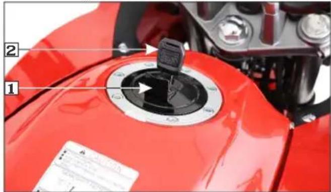 Close-up of a red motorcycle fuel injector with labeled parts and a warning label