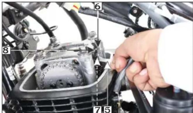 Close-up of a car engine component with numbered parts labeled 5, 6, and 7, showing hand tool interacting with engine body.
