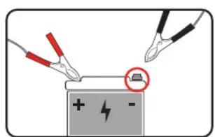 Diagram showing two pliers applying a battery to a terminal, with a magnified view highlighting the battery symbol.