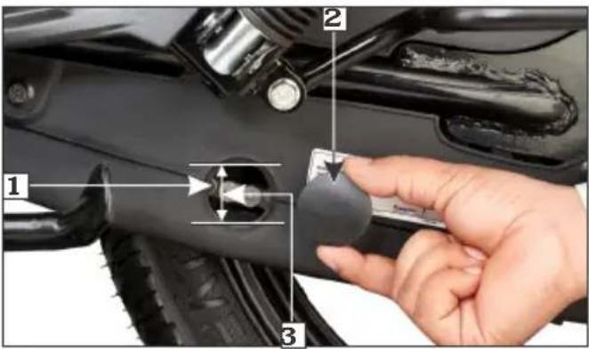 Close-up of a hand holding a mechanical component with numbered parts, likely for assembly or repair instructions.
