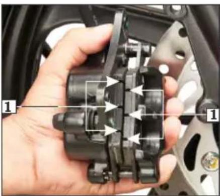 Close-up of a hand holding a mechanical component with numbered labels pointing to features