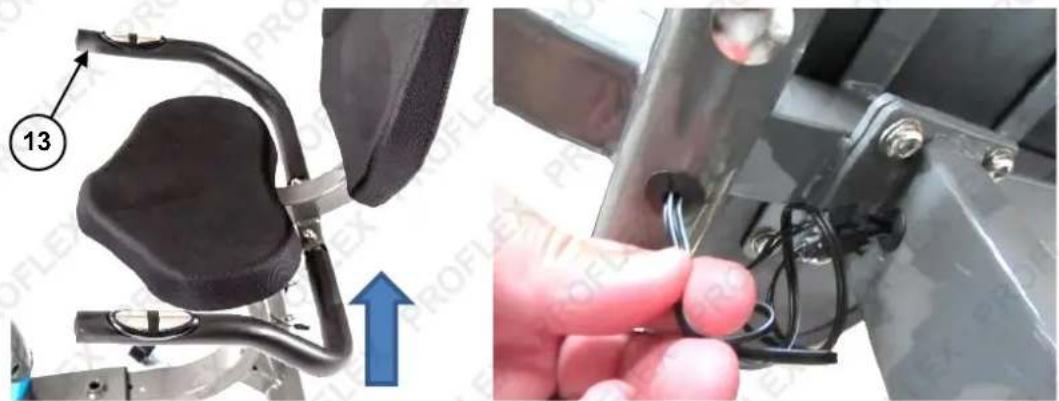 Close-up of a mechanical device with a black component and attached cable, showing a hand holding wires (no text or symbols visible)