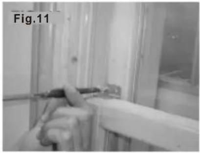 Close-up of a hand holding a pen, partially obscured by a window frame (no visible text or symbols)