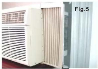 Exterior view of a white air conditioner unit with ventilation grilles, next to a gray wall-mounted panel (no visible text or symbols)