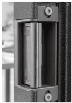 Close-up of a mechanical lock or latch component with mounting holes and a central internal mechanism (no visible text or symbols)