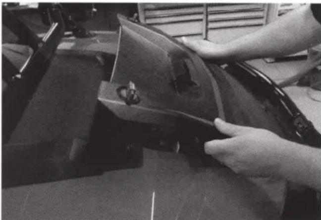 Close-up of hands operating a mechanical device with a wooden frame (no visible text or symbols)