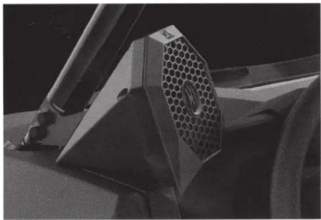 Close-up of a car's front wheel and side panel showing a hexagonal mesh component (no visible text or symbols)