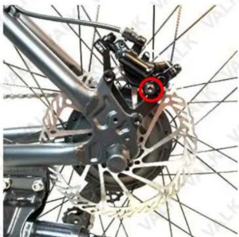 Close-up of a bicycle's front wheel and suspension components, showing mechanical parts and a red circle highlighting a specific component (no text or symbols visible)