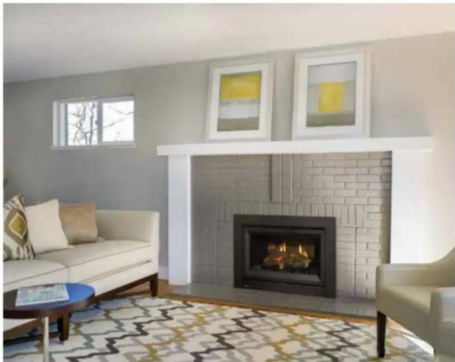 Interior living room with white sofa, brick fireplace, and patterned rug (no visible text or symbols)