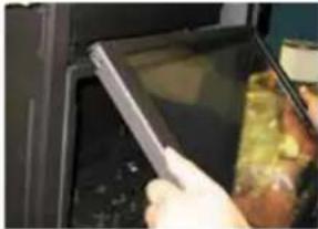 Close-up of a hand holding a tablet device inside a kitchen appliance (no visible text or symbols)