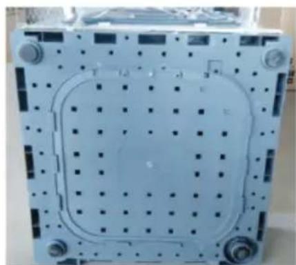 Exterior view of a mechanical component with grid pattern and mounting holes (no text or symbols visible)