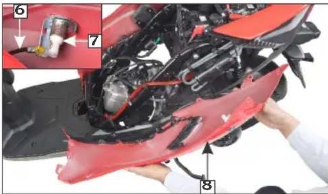 Close-up of a red motorcycle body with mechanical components and numbered parts, likely for repair or maintenance.