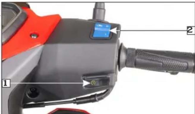 Close-up of a motorcycle's front-mounted device with labeled parts and control buttons