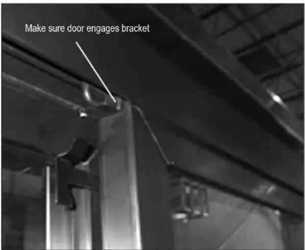 Make sure door engages bracket